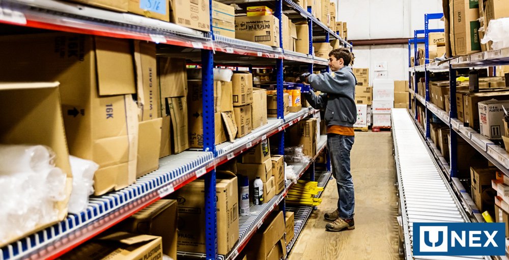 Warehouse worker picks item from industrial shelving